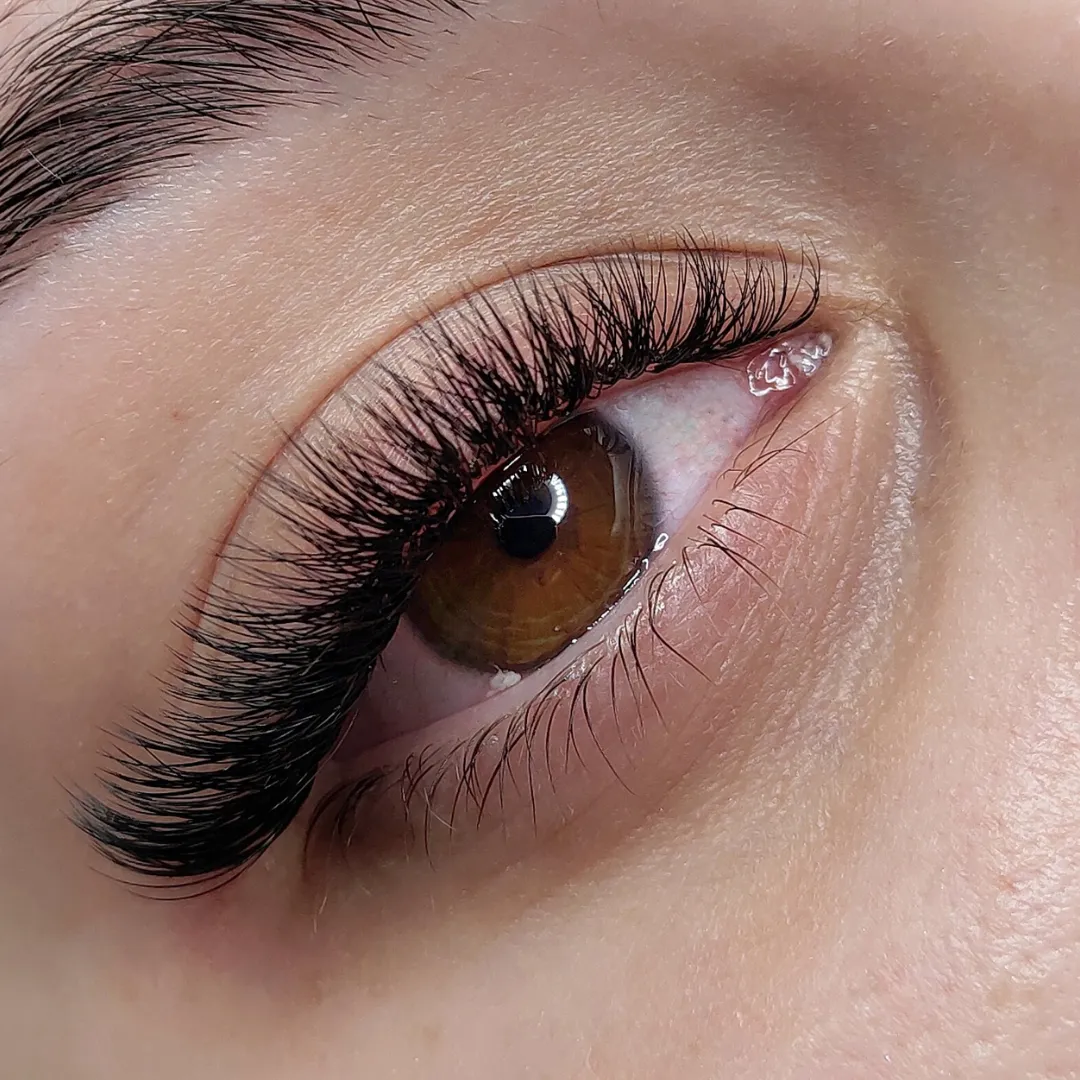 Close-up of a brown eye with expertly applied volume lash extensions by Sweet Chanice.