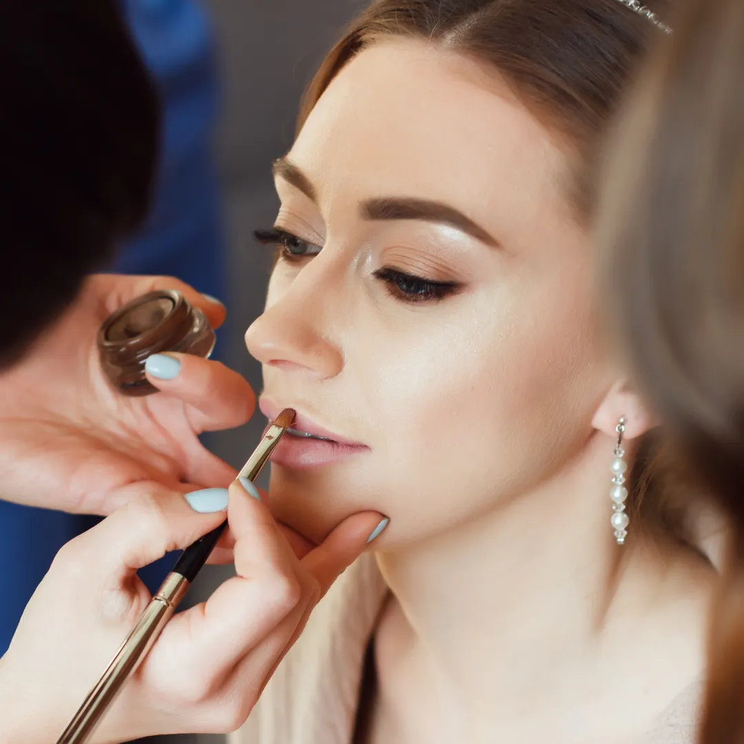 A bride receiving a professional makeup application by Sweet Chanice, showcasing a natural and elegant look.